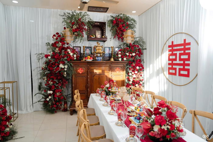 Bàn thờ gia tiên trang trí hoa đỏ và chữ hỷ